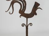 an old iron rooster sculpture on a stand on a white background