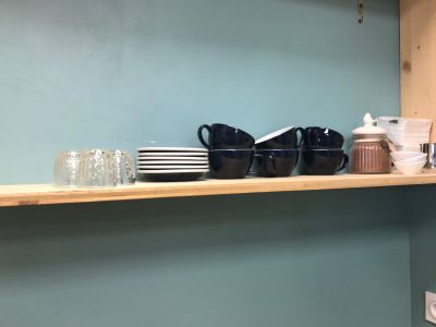 a shelf with cups and plates on it in the kitchen