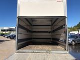 the back of a white truck with its door open in a parking lot