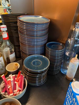 de nombreuses assiettes et bols remplis de nourriture sur le plan de travail