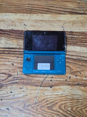 a blue nintendo wii game console sitting on a wooden table