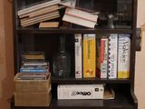 une bibliothèque noire sur laquelle sont posés de nombreux livres