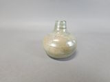 a small glass vase with a brown base on a table