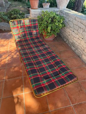 a dog that is sitting on a chair on the patio