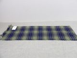 a close up of a blue and green plaid rug on a white surface