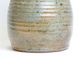 a close up of a vase on a white surface