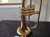 a brass trumpet sitting on a table with a black cloth