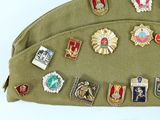 a green bag with a lot of badges on it