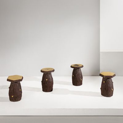 trois tabourets en bois sont posés sur une surface blanche devant un mur blanc