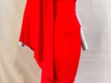 une robe rouge posée sur un présentoir à mannequin, sur fond blanc
