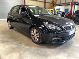 La voiture noire est garée dans un garage avec d'autres voitures.