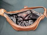 brown leather purse with zipper open on a blue background