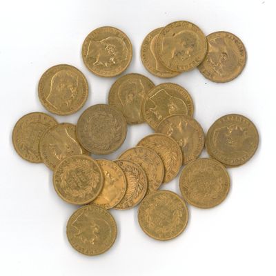 quelques pièces d'or posées sur une surface blanche, sur fond blanc
