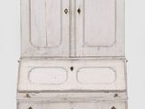 une vieille armoire blanche avec des tiroirs, surmontée d'autres tiroirs