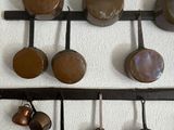 a lot of pots and pans hanging on the wall