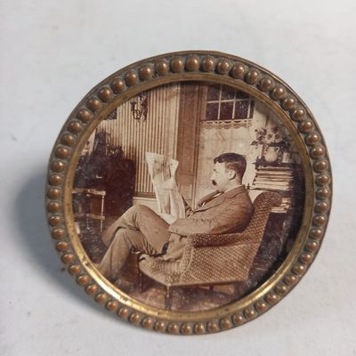 une photo d'un homme assis sur une chaise en train de lire un livre