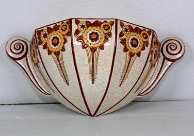 un bol blanc orné de motifs rouges et jaunes
