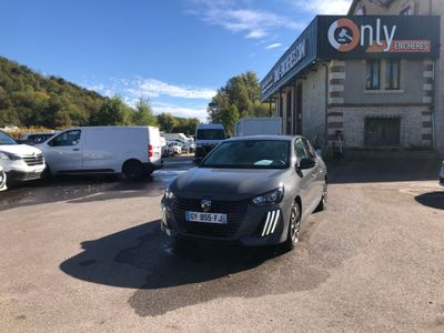 La voiture est garée devant l'immeuble, sur le parking.