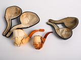 three different types of smoking pipes on a white surface