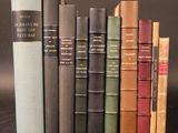 several old books are lined up on a shelf in front of a black background