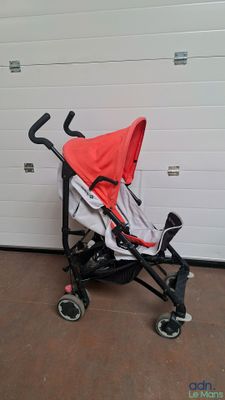 a baby stroller sitting in front of a garage door