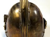 a bronze helmet with a bird on it on a white surface