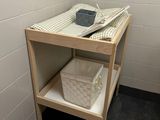 a small table with a basket on it in a bathroom