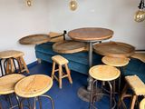 de nombreux tabourets et tables dans une pièce recouverte d'une moquette bleue