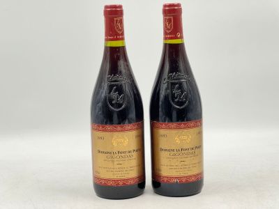 deux bouteilles de vin rouge posées l'une à côté de l'autre sur une surface blanche
