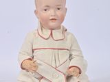 a baby doll sitting on the ground with a white background