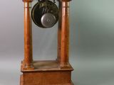 a small wooden clock sitting on a table next to a pair of scissors