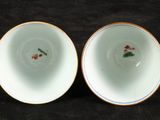 two white bowls with blue rims are sitting on a black surface