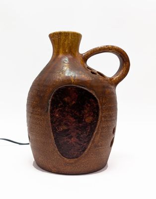 un vase brun posé sur une surface blanche