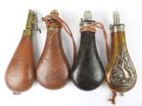 quatre modèles différents de flacons en cuir avec des anses métalliques, posés sur un fond blanc