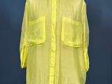 the yellow shirt is on a mannequin stand against a blue wall
