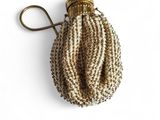 a close up of a small beaded purse on a white surface