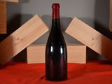 a bottle of red wine sitting on a red cloth