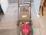 une image d'une tondeuse à gazon garée dans un garage
