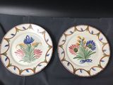 two plates with flowers painted on them on a table
