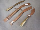 three knives are laying on a table with a bullet on one of them