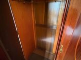 a wooden cabinet with a glass door in a room