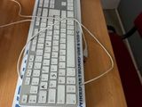 a computer keyboard and mouse on a desk with a box in the background