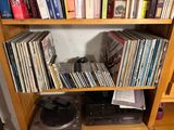 a book shelf full of cds and cassettes in a room