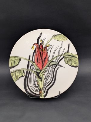 a plate with a flower on it on a black background