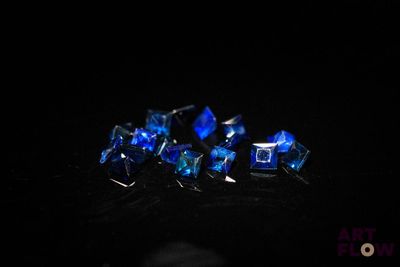 quelques cristaux bleus posés sur une surface noire