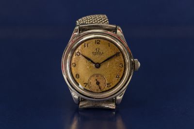 a close up of a wrist watch on a blue surface