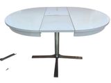 a white table with a metal base and a knife on it