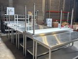 tables de travail en acier inoxydable dans un entrepôt équipé d'étagères et de rayonnages
