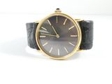 an image of a black and gold wrist watch on a white surface