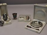 a silver plate and a silver cup and a silver spoon and a silver cup and a silver spoon and a silver cup and a silver cup and a silver
